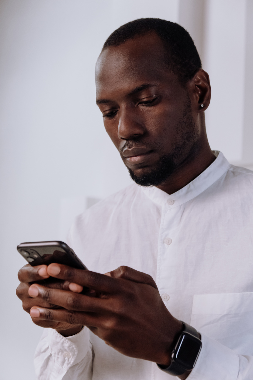 Man in White Dress Shirt Holding Black Smartphone